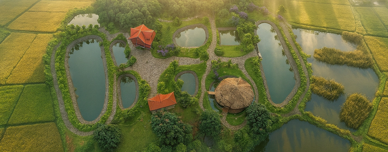 Aerial view of scenic water ponds and green gardens at The Hamlet Farmstead Resort Munnar