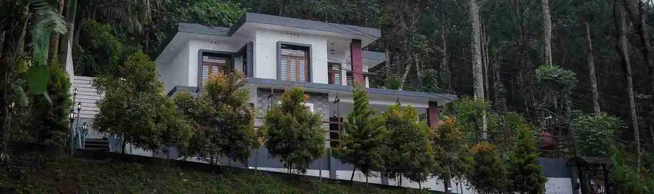 Exterior view of The Kalt Private Pool Homestay in Munnar surrounded by lush greenery and mountain mistle full view