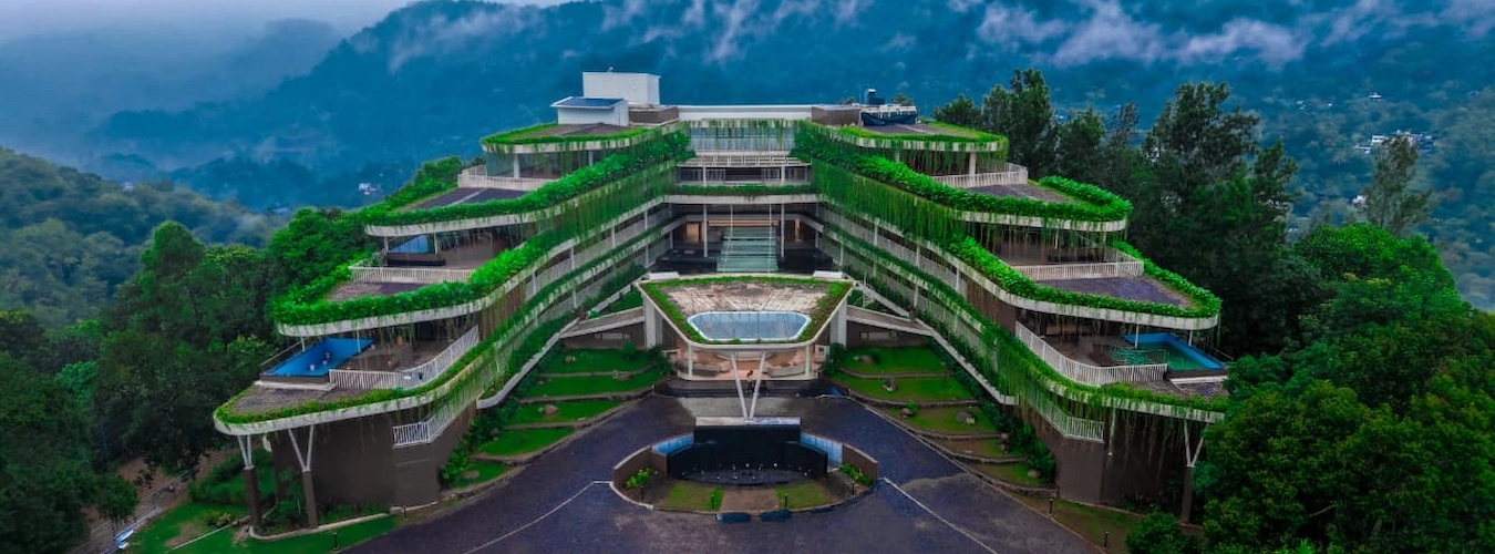 Aerial view of Mountree Munnar luxury resort nestled amidst green mountain landscapes