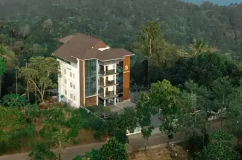 Exterior hillside view of Boulevard Hotel premium property surrounded by tropical trees in Munnar