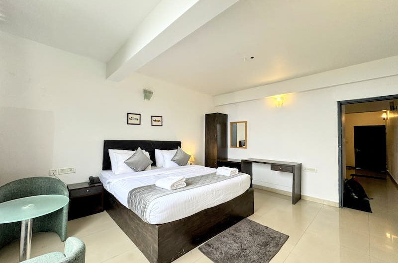 Scenic Deluxe Bedroom View at The Vue Munnar Retreat Resort in Munnar Overlooking Green Hills