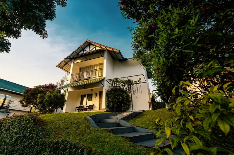 Premium hillside honeymoon villa cottage with paved stone pathway at The Leaf Resort Munnar