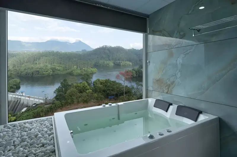 Private indoor Jacuzzi overlooking lush green hills and valleys at Eve Munnar Luxury Resort