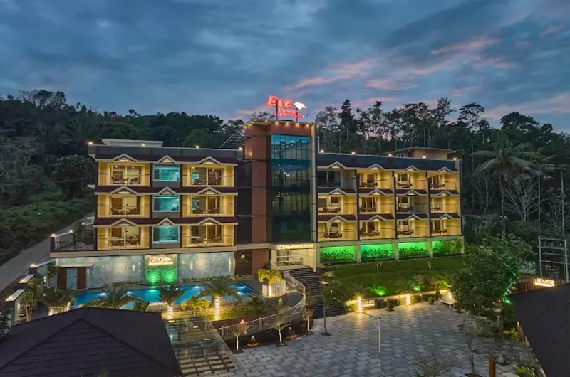 Beautifully illuminated exterior view of Eve Munnar Luxury Resort at night with ambient outdoor lighting