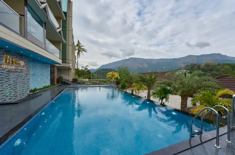 Luxury infinity swimming pool with a panoramic view of the mountains at Eve Munnar Luxury Resort