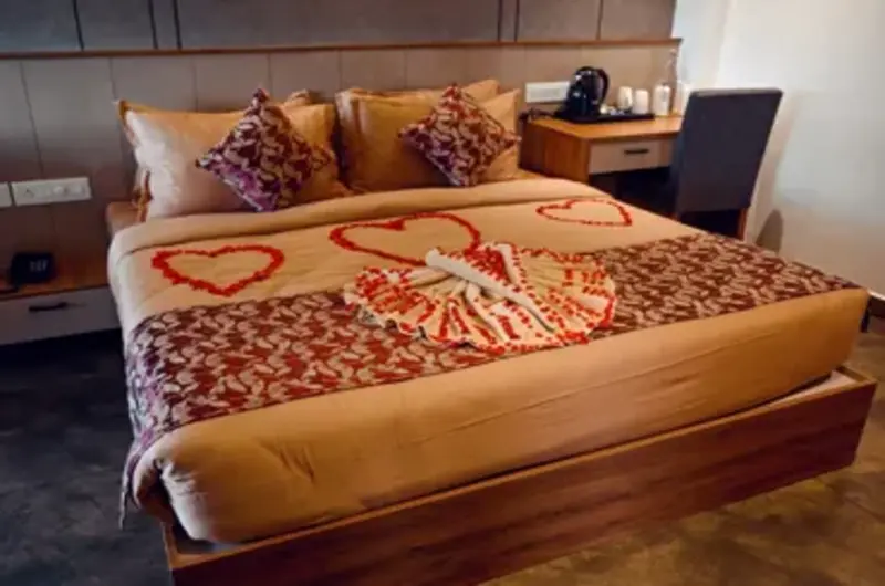 Luxury hotel bed decoration with towel art and floral accents at Boulevard Hotel Munnar