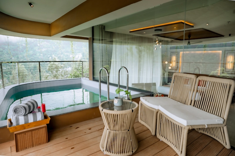 Spacious luxury bedroom suite interior with panoramic window views at Mountree Munnar
