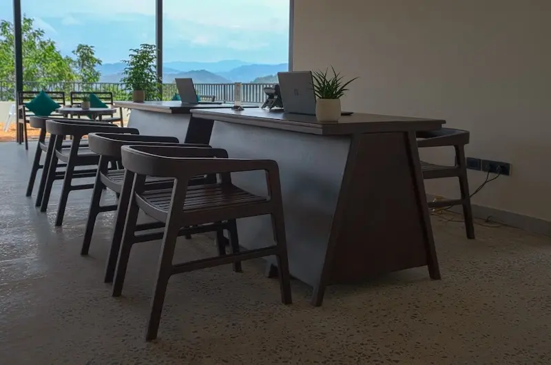 Modern high-bar outdoor seating area overlooking forest views at Maram Resort Mamalakandam