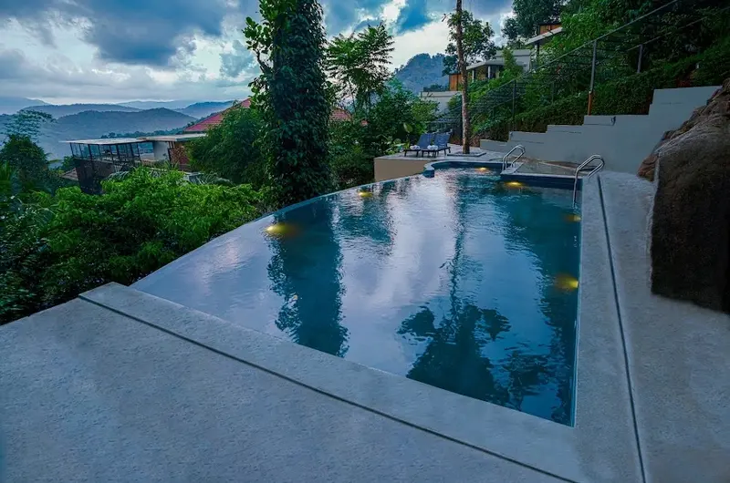 Infinity swimming pool with scenic mountain and forest views at Maram Resort Mamalakandam