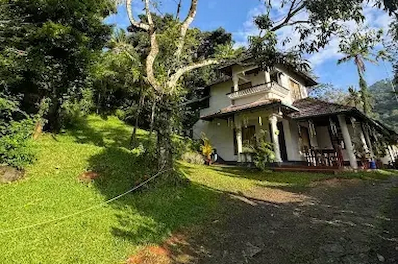 Exterior view of Thoppil Homestay surrounded by hills and trees in Munnar