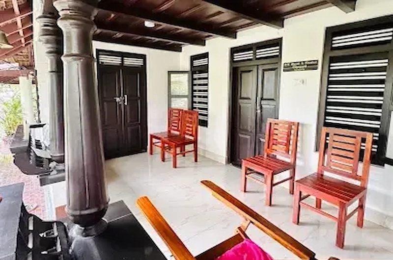 Traditional Kerala style wooden verandah and seating area at Thoppil Homestay