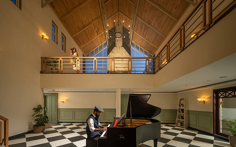 Luxury resort lobby featuring high ceilings and piano lounge at 1924 Clock House Resort Munnar