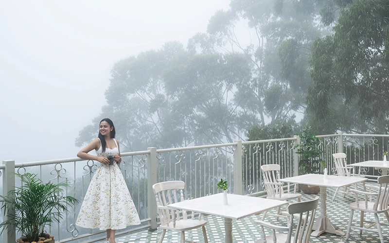 Elegant glasshouse cafe dining space with garden view at 1924 Clock House Resort Munnar