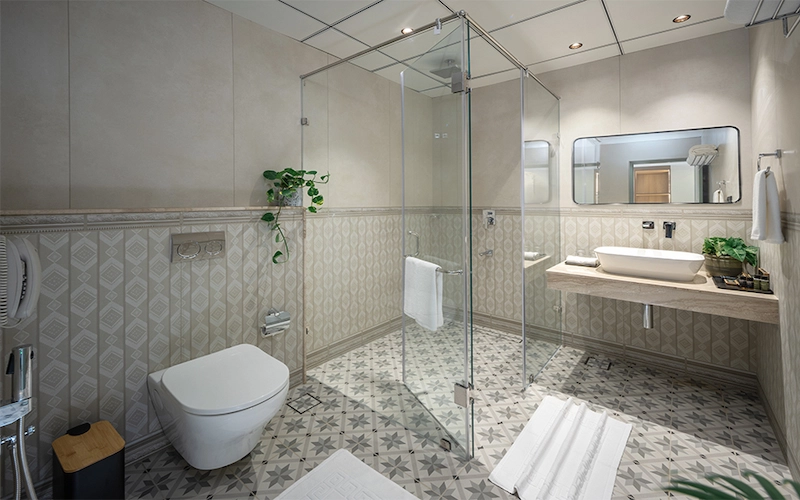 Modern attached bathroom with modern vanity and glass shower at 1924 Clock House Resort Munnar