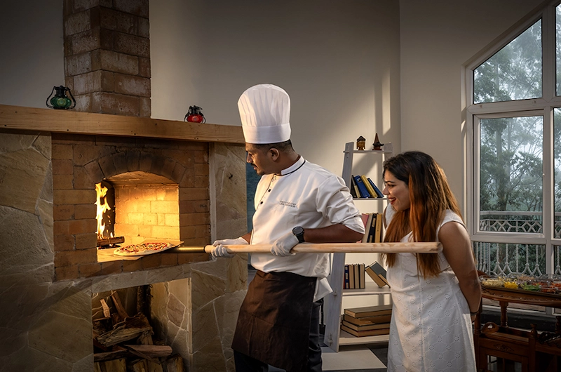 Resort restaurant dining area with live cooking service at 1924 Clock House Resort Munnar