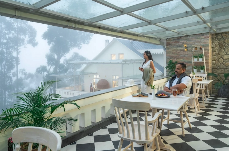 Couple enjoying outdoor dining on a balcony with mountain view at 1924 Clock House Resort