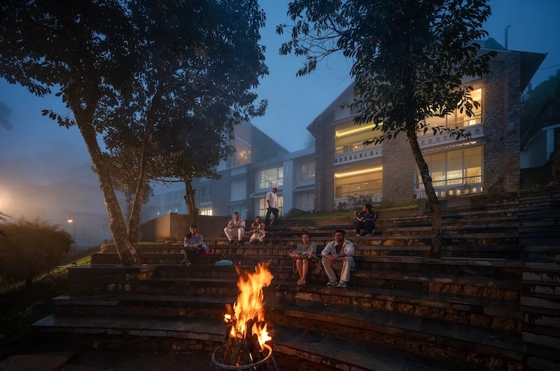 Outdoor campfire area lit up at night at 1924 Clock House Resort Munnar
