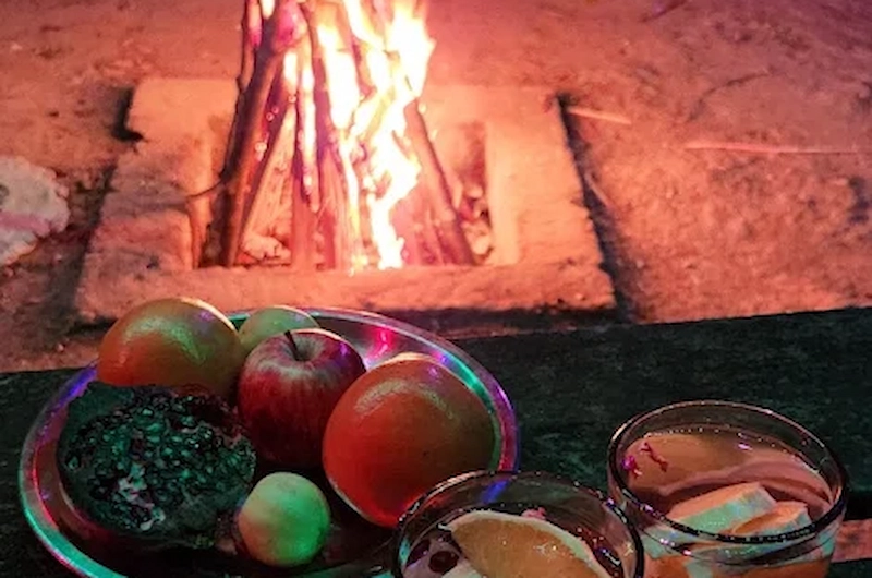 Evening campfire setup with rustic seating and surrounding greenery at Pepper County Farm Stay Munnar