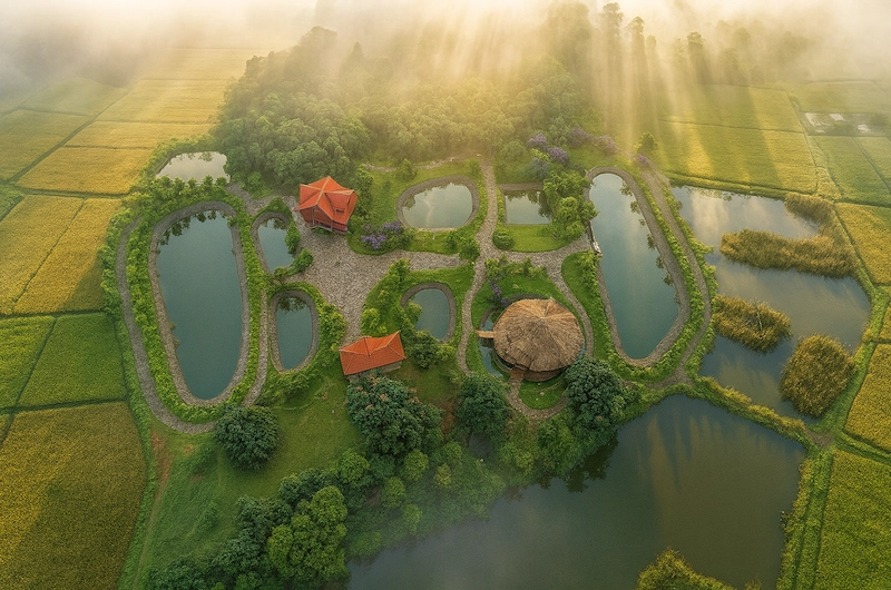 Aerial view of scenic water ponds and green lawn gardens at The Hamlet Farmstead Resort Munnar