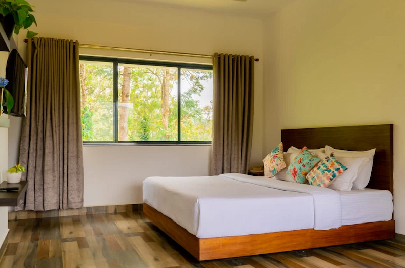 Elegantly furnished resort room featuring wooden interior and natural outdoor light in Munnar
