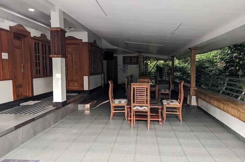 Outdoor seating porch overlooking surrounding nature and greenery at 4 Acre Woods Farm Stay Munnar