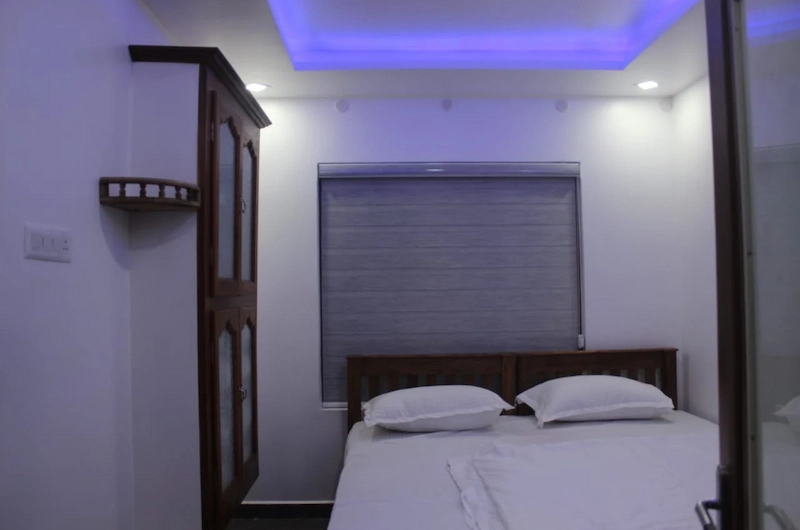 Comfortable guest bedroom with double bed and ambient lighting at 4 Acre Woods Farm Stay Munnar