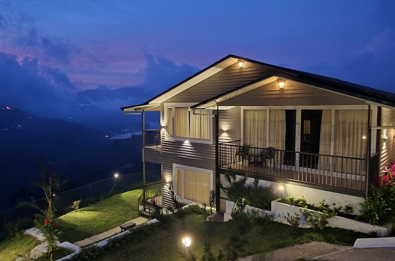 Illuminated resort cottage exterior with mountain background view at Wild Lilly