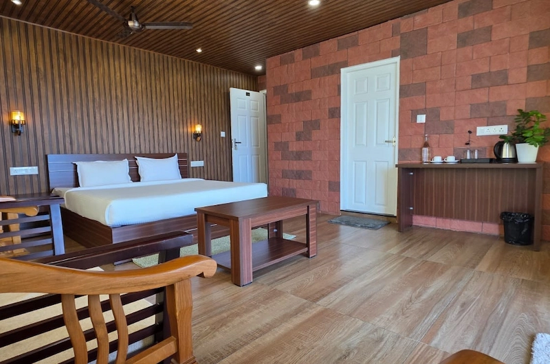 Spacious resort bedroom with double bed, wooden finishes, and large viewing window
