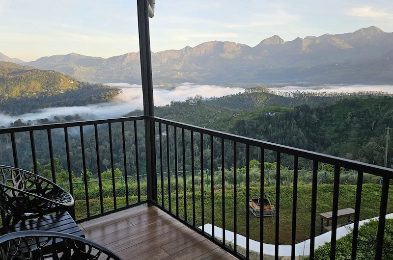 Balcony deck view overlooking misty mountain hills at Wild Lilly Eco Tourism