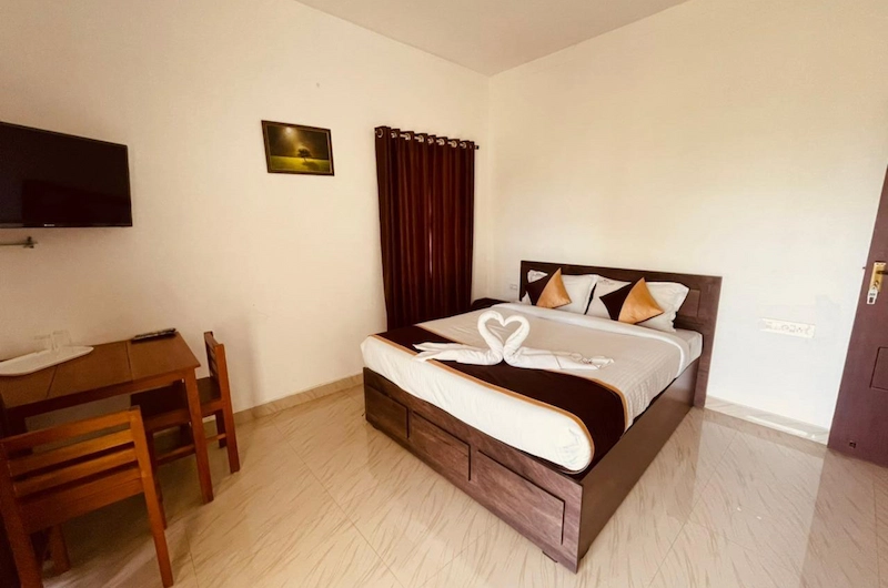 Cozy double bedroom setup with warm interior lighting at Flamingo Resort Munnar