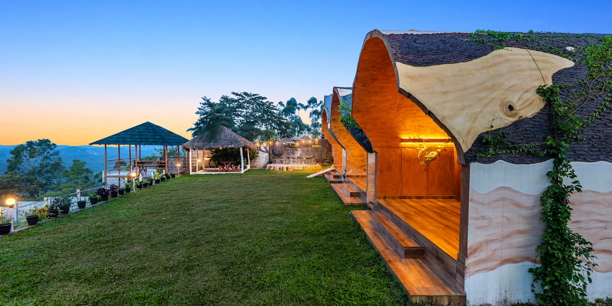 Traditional wooden cottage architecture nestled amidst green tropical trees in Munnar
