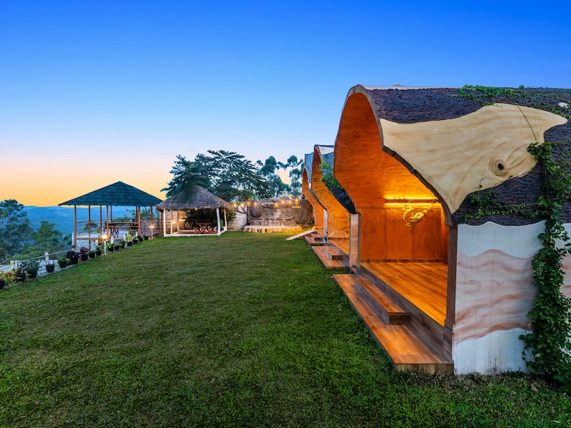 Glamping tent setup with wooden deck overlooking green landscape garden at Jai Hill Munnar